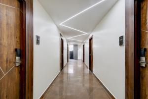 a corridor in a building with white walls and wooden doors at FabHotel Prime Srishoin in Hyderabad