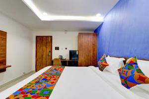 a bedroom with a large bed with a colorful blanket at FabHotel Prime Srishoin in Hyderabad