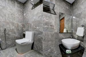 a bathroom with a toilet and a sink at FabHotel Prime Srishoin in Hyderabad