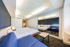 Habitación de hotel con 2 camas y sofá en L stay＆grow晴海 en Tokio