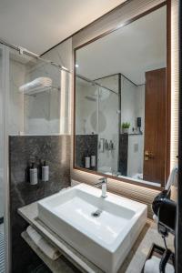 a bathroom with a white sink and a large mirror at M2 Square by Monday Premium in Nagpur