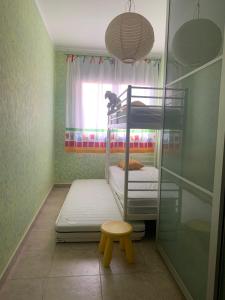 Kleines Zimmer mit 2 Etagenbetten und einem Stuhl in der Unterkunft Perfect located family flat in Lloret de Mar