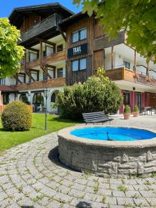 上斯陶芬的住宿－Trail Hotel Oberstaufen，前面有蓝色泳池的建筑