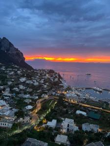 una vista aérea de una ciudad con la puesta de sol sobre el océano en Luxury Flat in Capri, en Capri
