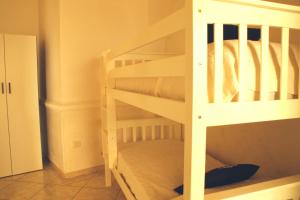 Ce lit superposé blanc se trouve dans un dortoir. dans l'établissement Stella Marina, à Porto Cesareo