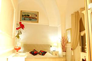 une chambre avec un canapé et un vase avec une fleur dans l'établissement Stella Marina, à Porto Cesareo