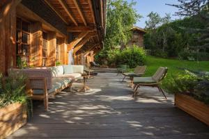 eine Terrasse mit Sofas und Stühlen auf einem Haus in der Unterkunft Magic Megève Bois in Demi-Quartier