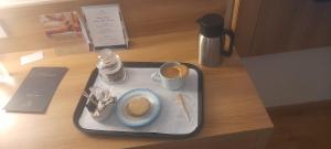 Kashi dham Homestay ( close to Kashi Vishwanath temple and Ghats) في فاراناسي: صينية مع صحن من الطعام على طاولة