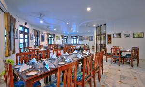 a dining room with a long table and chairs at Tiger Den Resort in Khilchipur