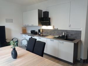 a kitchen with a sink and a table with chairs at Work and Stay Meinezhagen 5 schlafzimmer 10 betten, 2 badezimmer,150 qm in Meinerzhagen