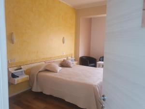 a bedroom with a bed and a yellow wall at Hotel Ristorante Supersonik in Acri