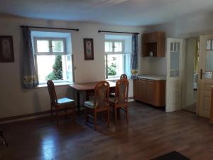 a kitchen with a table and chairs and two windows at Chalupa Sehradický mlýn in Sehradice +17 photos