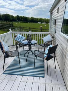 a patio with a table and chairs on a deck at Countryside 3-bedroom Static Caravan in Llanerchymedd +14 photos
