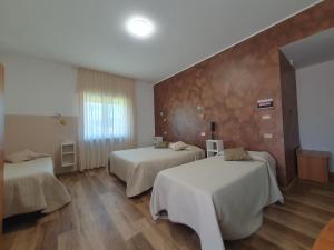 Hotel Ristorante Supersonik في Acri: غرفه فندقيه سريرين وجدار