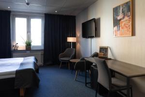 Habitación de hotel con cama, escritorio y sillas en The Brewery Hotel en Karlskrona