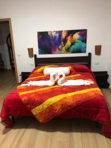 ein Bett mit einer bunten Decke und zwei Handtüchern in der Unterkunft Villa Andres in Sassari