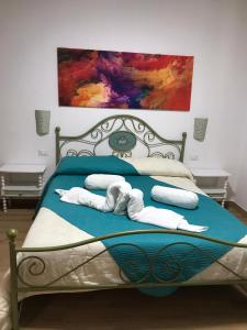 ein Schlafzimmer mit einem Bett mit Handtüchern und einem Gemälde in der Unterkunft Villa Andres in Sassari