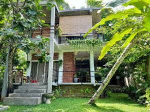 una casa con scale e alberi nel cortile di Track Monkey's Lodge a Seeduwa