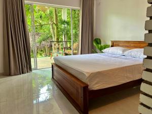 una camera da letto con un letto e una grande finestra di Track Monkey's Lodge a Seeduwa