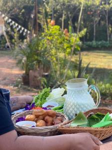 a table with two baskets of food and a vase at Baanlamun in Ban Dong Bang +6 photos