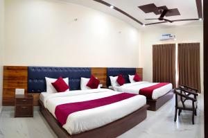 a bedroom with two beds with red pillows at Hotel Hill River View Resort in Uttarkāshi