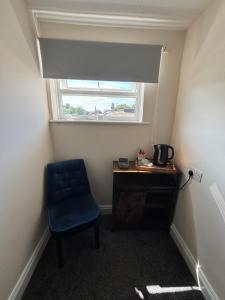 a room with a blue chair and a window at Half Moon Inn in Middlesbrough