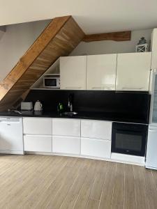 a kitchen with white cabinets and a wooden floor at Papes oaze in Pape +7 photos