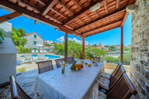 a patio with a table and chairs and a pool at Villa Bonaca Cozy Family & Friends Retreat with Heated Pool in Sumartin