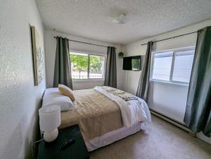 a bedroom with a bed and two windows at Your Home Away from Home in Payette