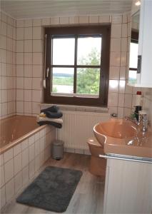 a bathroom with a tub and a toilet and a sink at Haus am Seeufer, Weißenstadt in Weißenstadt +18 photos