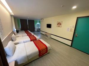 クアラ・トレンガヌにあるN&L HOTEL KUALA TERENGGANUのベッド2台とテレビが備わるホテルルームです。