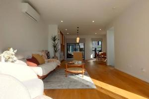a living room with a white couch and a table at Brand-new Modern Princess in One Tree Hill in Auckland