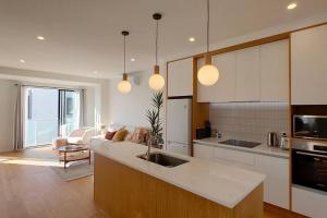 a kitchen with a sink and a living room at Brand-new Modern Princess in One Tree Hill in Auckland