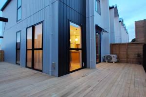 a building with a large glass door on a patio at Brand-new Modern Princess in One Tree Hill in Auckland