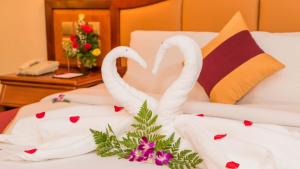 two white swans sitting on top of a bed at Phnom Penh Hotel in Phnom Penh