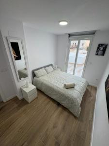 a bedroom with a bed and a large window at Benicasim Village by Tucasanlaplaya in Benicàssim