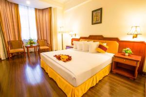 a bedroom with a large bed in a hotel room at Phnom Penh Hotel in Phnom Penh