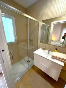 a white bathroom with a shower and a sink at Benicasim Village by Tucasanlaplaya in Benicàssim +33 photos