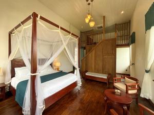 a bedroom with a canopy bed and a staircase at PHA NYA RESIDENCE in Luang Prabang