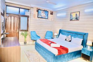 a bedroom with a blue bed and two blue chairs at Divine India Service Apartment 3 BHK D-198 Saket in New Delhi