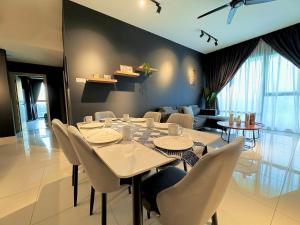 uma sala de jantar com mesa e cadeiras e uma sala de estar em Southkey Mosaic Apartment em Johor Bahru