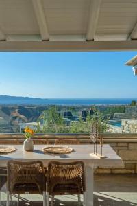 una mesa con sillas y vistas al océano en Indigo Villa with private Pool-Gym-Sauna-BBQ by Hospi, en Heraclión