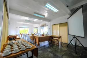una habitación con varias mesas y una pantalla blanca en Malapascua Exotic Island Dive Resort en Daanbantayan