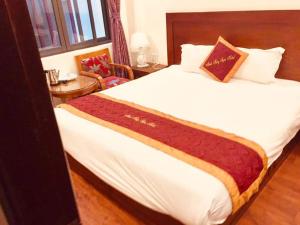 サパにあるGolden Moon Sapa Hotel by - BAY LUXURYのベッドルーム(赤い毛布付きの白い大型ベッド1台付) +1枚の写真