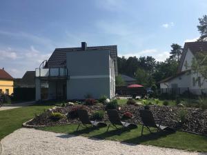 two chairs in a garden in front of a house at Ferienhaus _GlueckSEEligkeit_ in Großkoschen