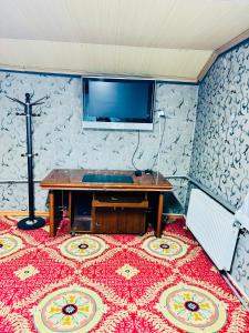 a room with a table and a tv on a wall at City Hostel & Tours in Ulaanbaatar