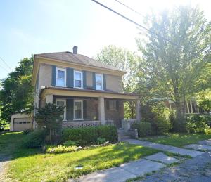 伯克利斯普林斯Broadway Cottage - Town, Hot Tub, Fire Pit, Grill, Wifi, Family Friendly, Pet Friendly的前面有草地的房屋