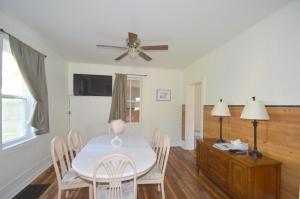 伯克利斯普林斯Broadway Cottage - Town, Hot Tub, Fire Pit, Grill, Wifi, Family Friendly, Pet Friendly的一间带桌椅和吊扇的餐厅