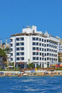 a hotel on the beach with people on the beach at Asena Hotel in Kusadası