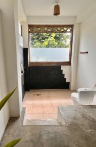 a bathroom with a toilet and a window at Vertical House Bali in Uluwatu